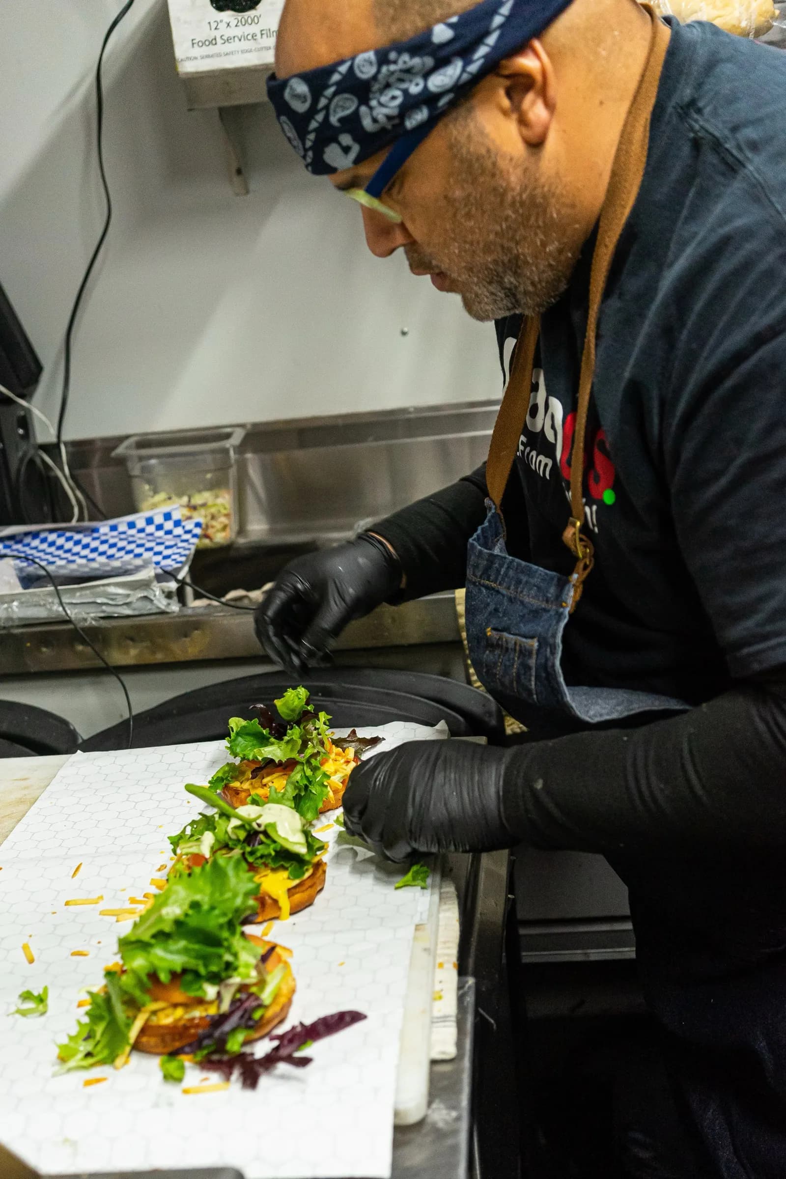 Chef Rodolfo plating burgers at Latinus Foods kitchen