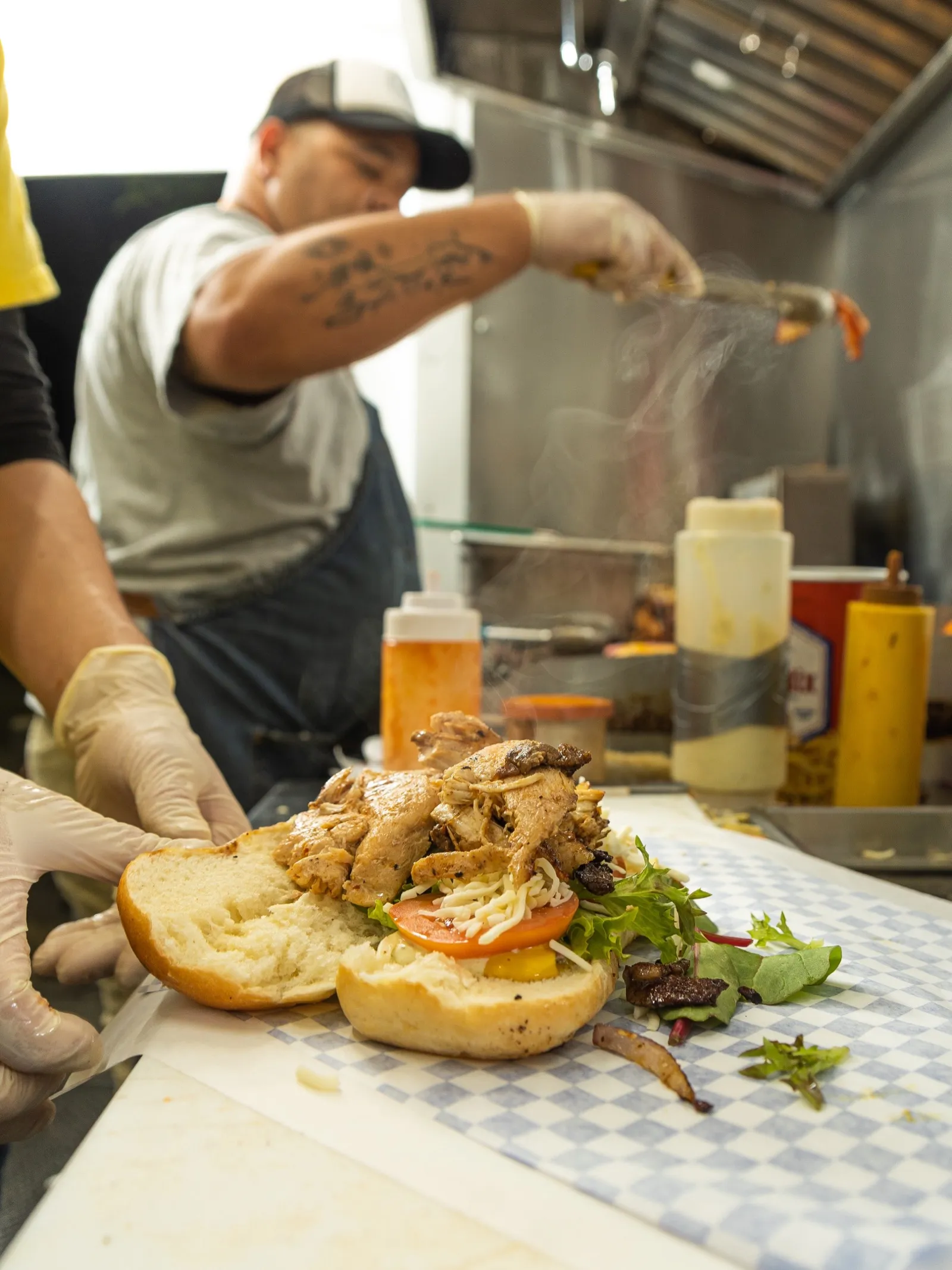 Assembling a fresh Venezuelan pepito with steaming meat
