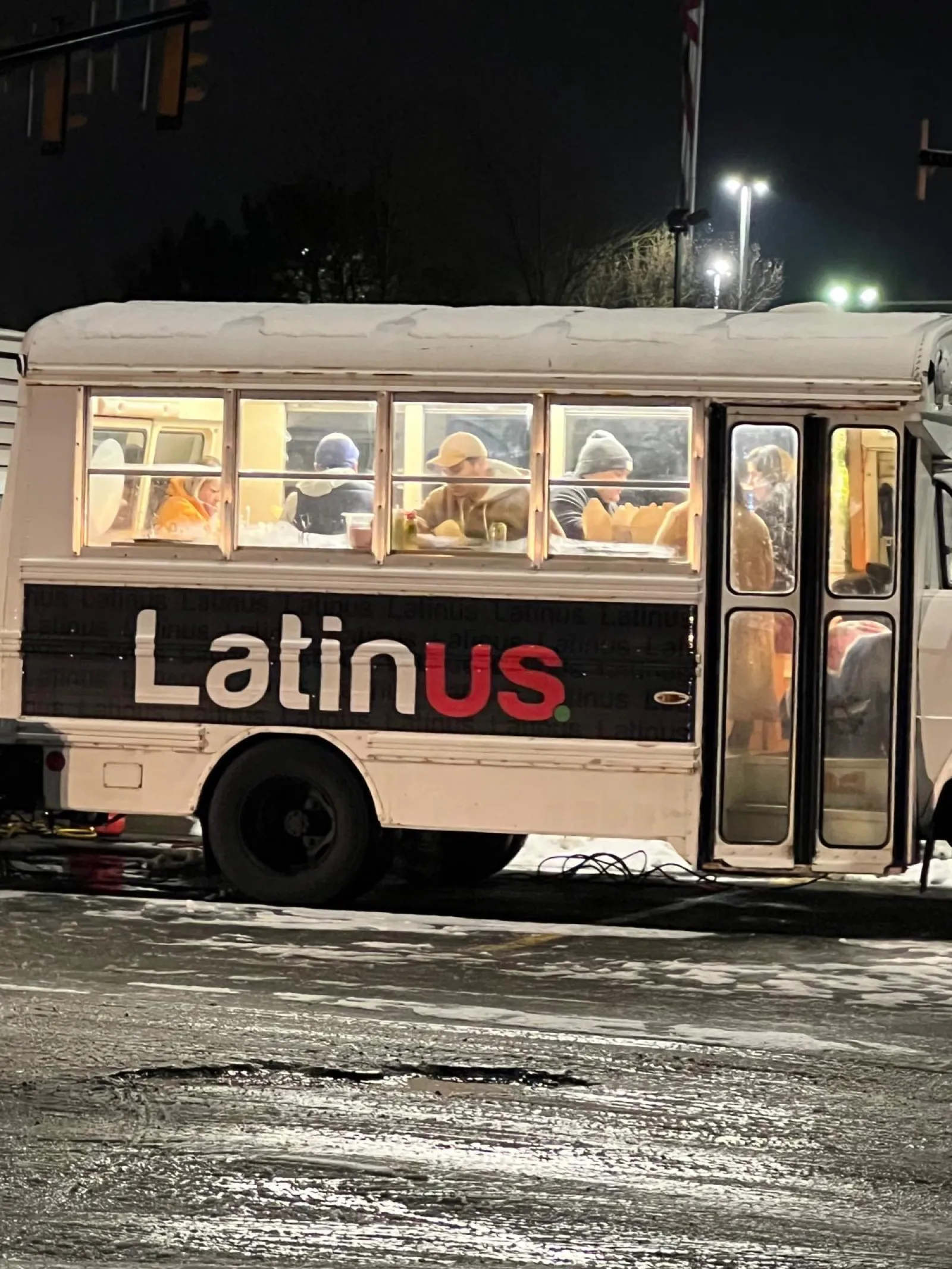 The Latinus Gastrobus at night with guests dining inside